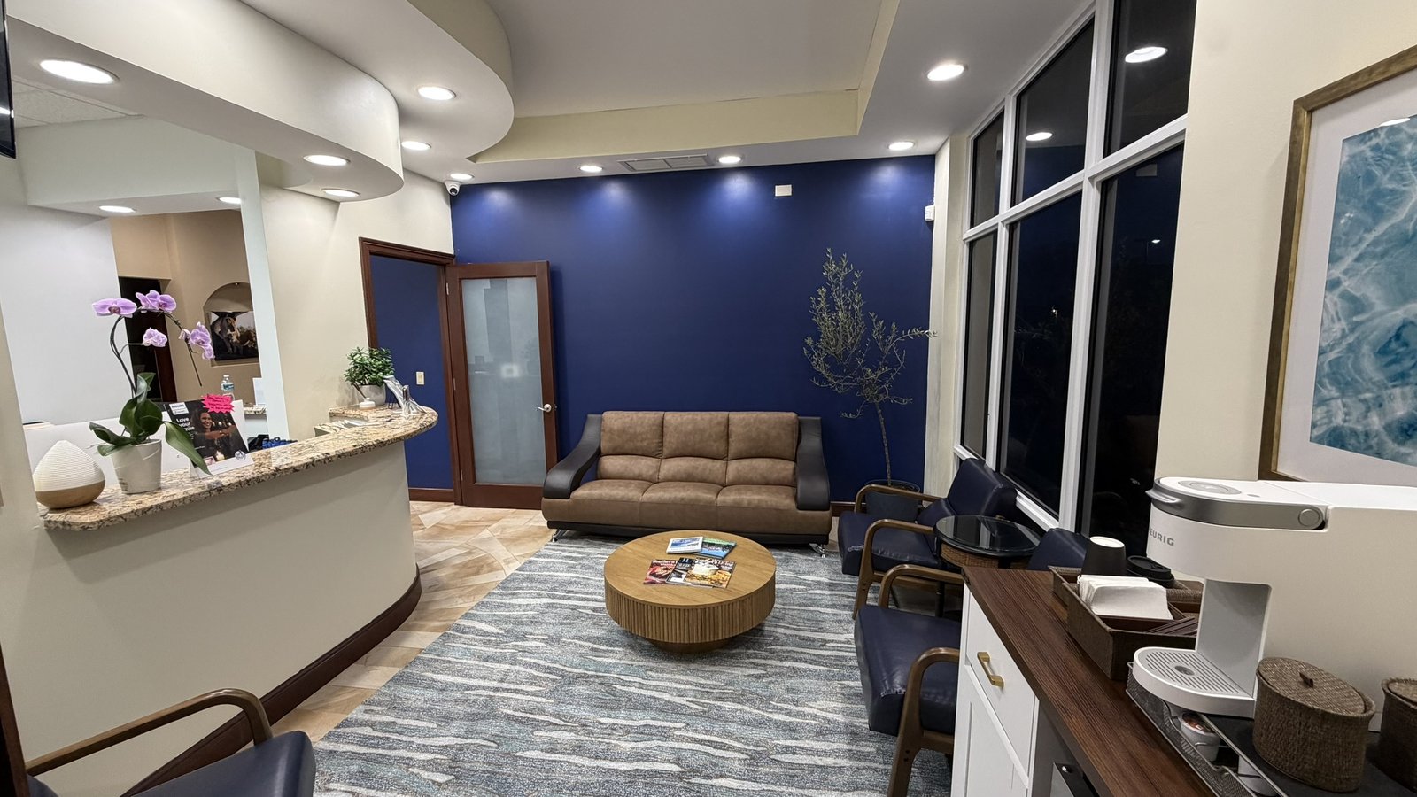 Complimentary Keurig coffee bar at Sunset Smiles Cosmetic Dentistry — welcoming lounge details including olive tree, artwork and coffee station for patients