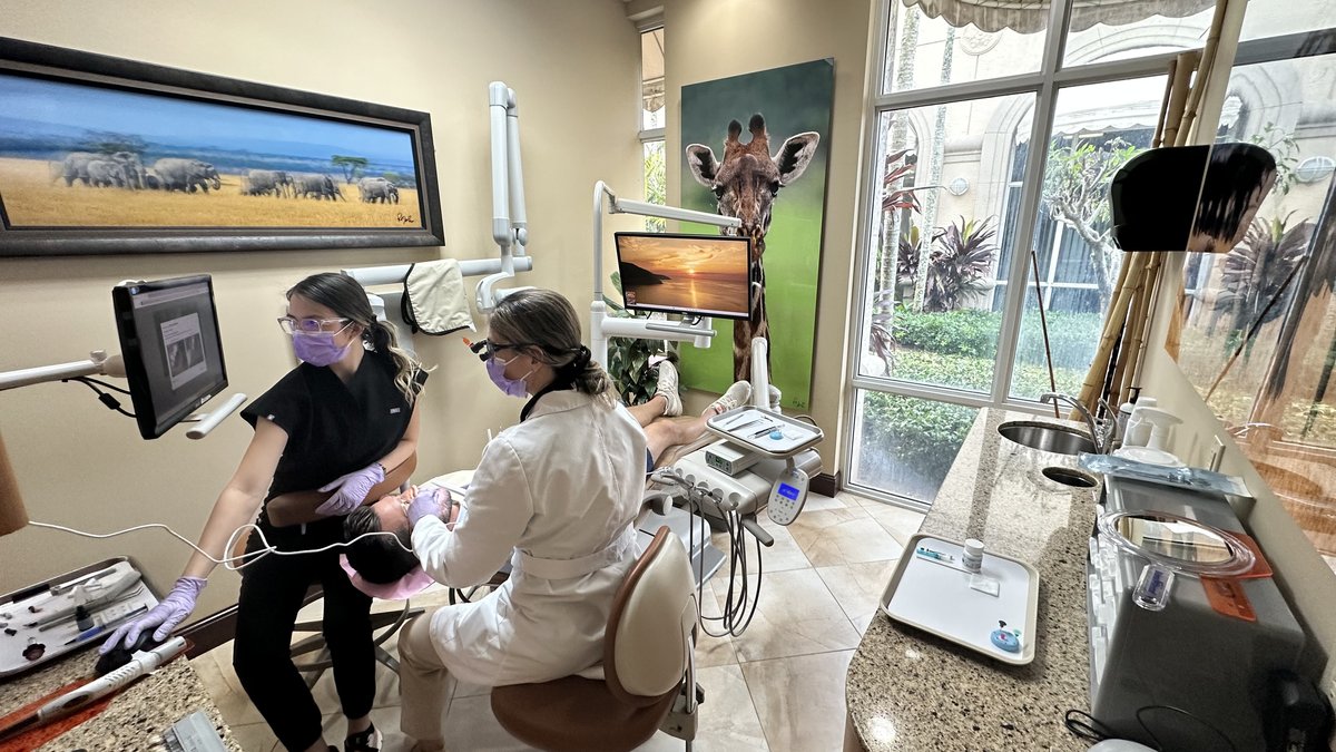 Dr. Magela Martinez and her assistant working in a modern operatory at Sunset Smiles in Jupiter, FL