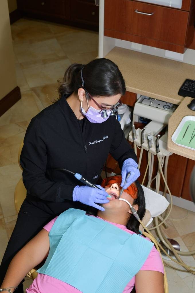 A Sunset Smiles hygienist treating a patient in the operatory