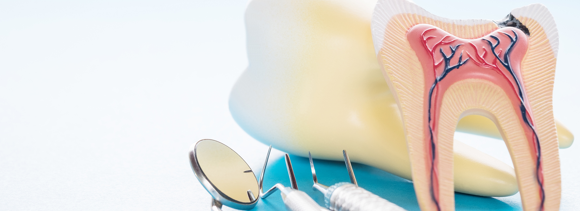 The image shows a close-up of dental tools including a toothbrush, dental floss, and a dental mirror, with a focus on oral hygiene items.